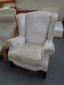 A contemporary wing backed armchair in brocade fabric