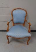 A carved beech framed salon armchair in blue fabric