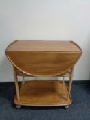 An Ercol elm and beech three tier flap-sided tea trolley, catalogue no.