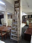 A large ten step wooden folding ladder together with a further five step ladder