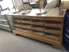An early twentieth century glazed haberdashery cabinet with sixteen drawers