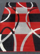 A contemporary machine made carpet with red and black design