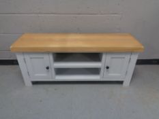 A contemporary entertainment stand with painted base fitted cupboards and shelves below