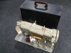 A cased 20th century Singer electric sewing machine with lead