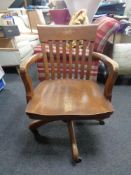 An Edwardian oak swivel desk armchair