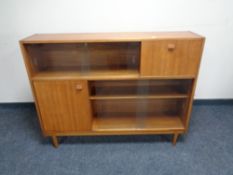 A mid twentieth century sliding glass door bookcase,