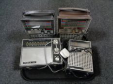 A tray containing four solid state radios