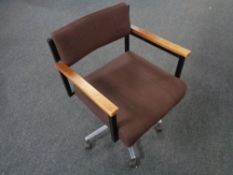 A mid twentieth century teak armed swivel office armchair