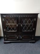 An oak double door book case with leaded glass doors,