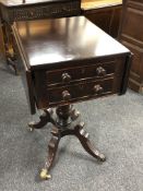 A Regency mahogany flap sided pedestal table fitted with two drawers, on brass feet.