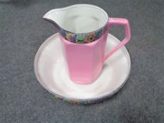 An antique English pottery pink floral wash jug and basin