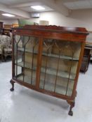 An Edwardian mahogany double door display cabinet on claw and ball feet