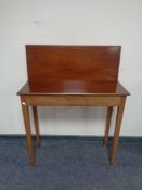 A narrow mahogany turnover top table.