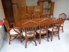 A Regency style inlaid mahogany twin pedestal dining table with leaf,