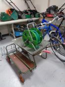 A metal wheelbarrow together with a folding sack barrow/trolley and a hose pipe on reel