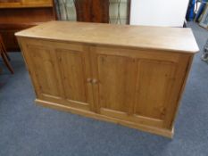 An antique pine double door sideboard.