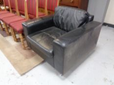 A contemporary black leather low back armchair on chrome legs