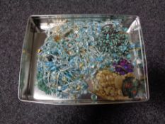 A tin of costume jewellery including faux turquoise beads