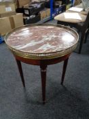 A circular mahogany marble topped occasional table with brass gallery.