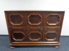 A 20th century oak six door, three drawer sideboard on bun feet.
