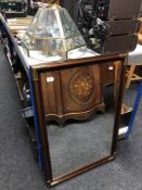 A contemporary framed bevel edge mirror together with a brass and glass pendant ceiling light.