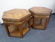 A pair of hexagonal two tier tables with brass handles and mounts.