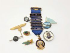 A group of silver and other badges