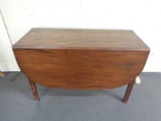 An antique mahogany drop leaf table