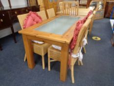 A contemporary pine dining table with a glass inset panel together with a set of six bamboo and