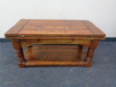 A contemporary hardwood two tier turnover top coffee table.