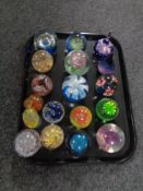 A tray of eighteen assorted glass paperweights