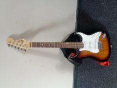 A Squier Strat by Fender electric guitar in carry bag.