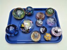 A tray of twelve assorted glass paperweights