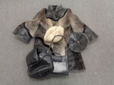 A box containing a simulated fur coat with matching hat together with further hat and two leather