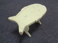 A painted cracket in the shape of a fish.