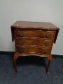 A Georgian style serpentine fronted three drawer flap sided chest,