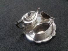 A three piece plated tea service on shaped plated tray.