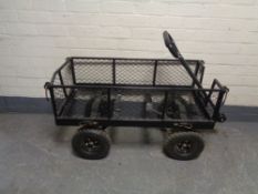A wire metal four wheel garden trolley