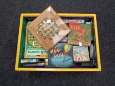 A plastic crate containing quantity of vintage and later games and puzzles