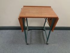 A mid 20th century teak topped bed table on tubular metal legs.