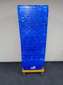 15 blue plastic storage crates together with two dollies.