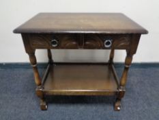 An oak two tier side table, fitted a drawer.