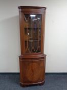 A mahogany glazed door corner display cabinet, fitted cupboard beneath.