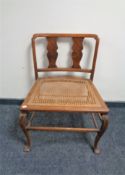 An Edwardian oversized dressing table chair with bergere seat.