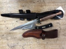 An old timer knife in leather scabbard together with a further copper handled knife in sheath