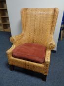 A wicker wing backed armchair