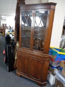 A Regency style double door corner display cabinet with astragal glazed doors and cupboards beneath