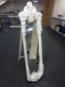 An ornate white cheval mirror
