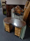 A mid century kidney shaped dressing table with triple mirror
