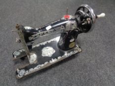 An antique Grand hand sewing machine.